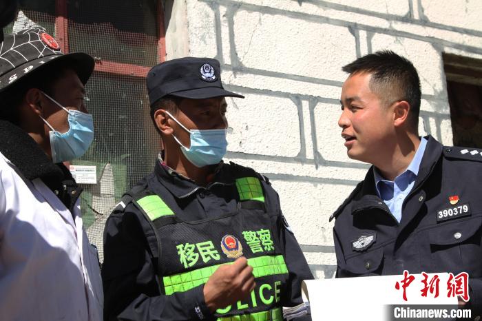 图为王卿龙(右一)在沿途边检站，了解过往人员和疫情防控情况。 赵朗 摄