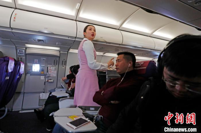 王姝樱在客舱里记下还在熟睡的旅客，以便旅客醒来第一时间为其服务。 殷立勤 摄